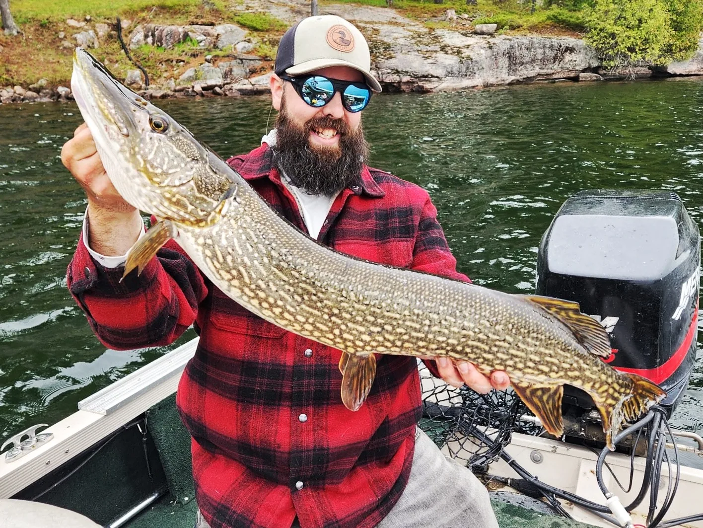 Andrew from Fishing Loons holding a northern pike while fishing.