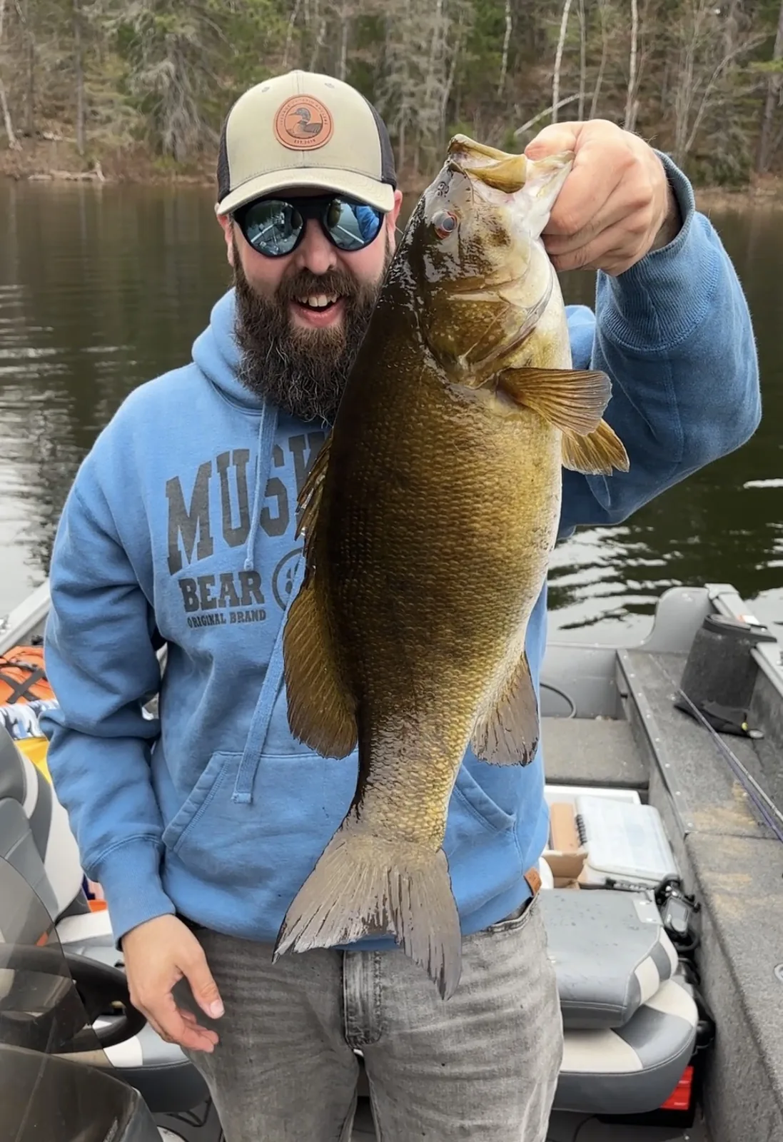Andrew from Fishing Loons holding a smallmouth bass while fishing.