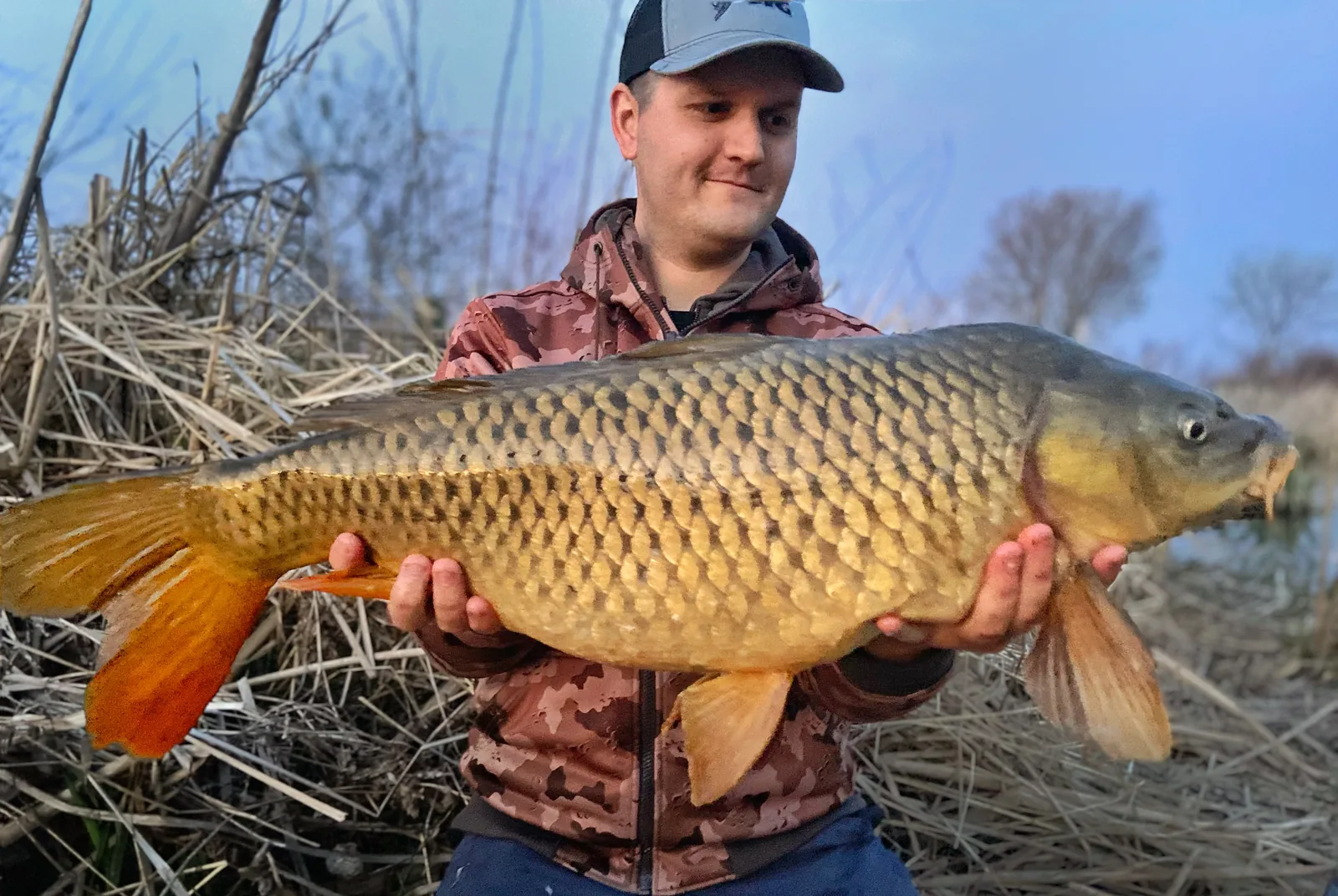 Jesse from Fishing Loons holding a common carp while fishing.