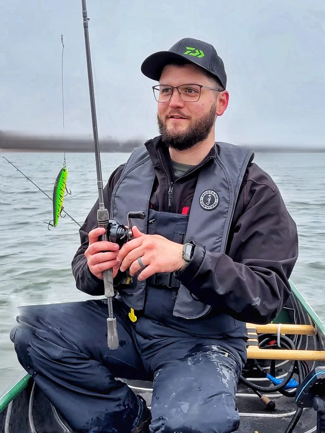 Jesse from Fishing Loons holding fishing gear on the water.
