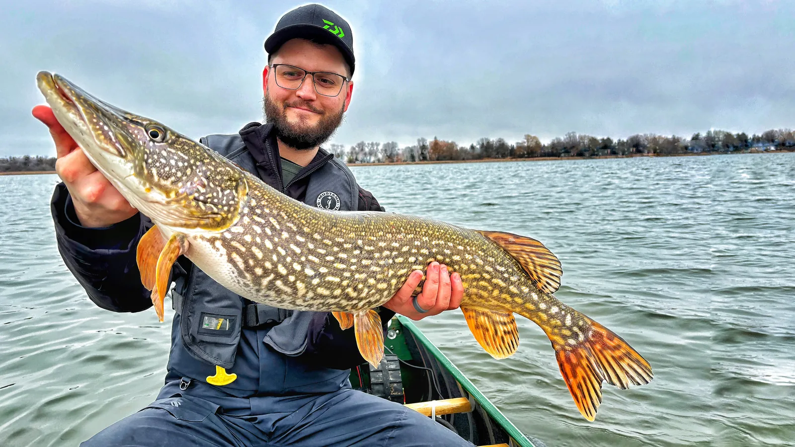 Jesse from Fishing Loons holding a northern pike while fishing.