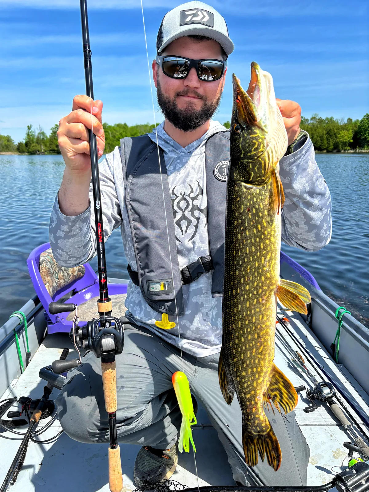 Jesse from Fishing Loons holding a northern pike while fishing.