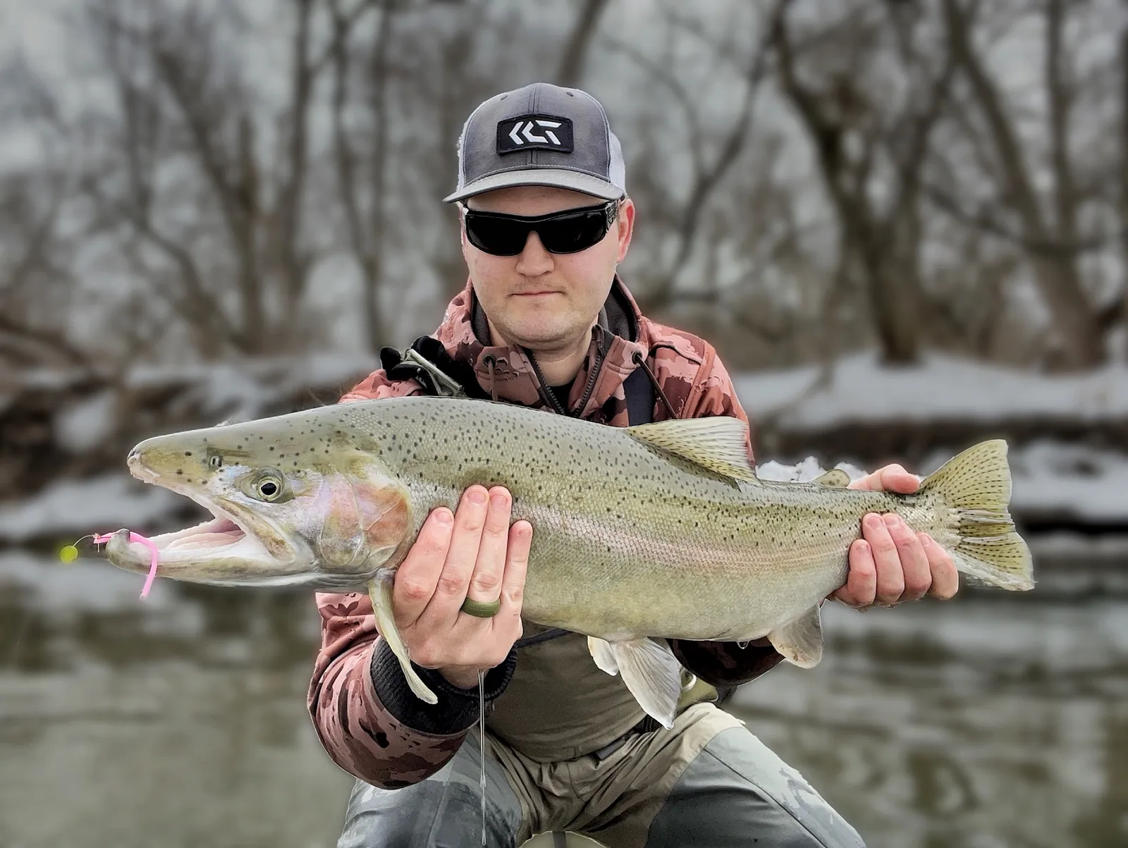 Jesse from Fishing Loons holding a rainbow trout / steelhead while fishing.