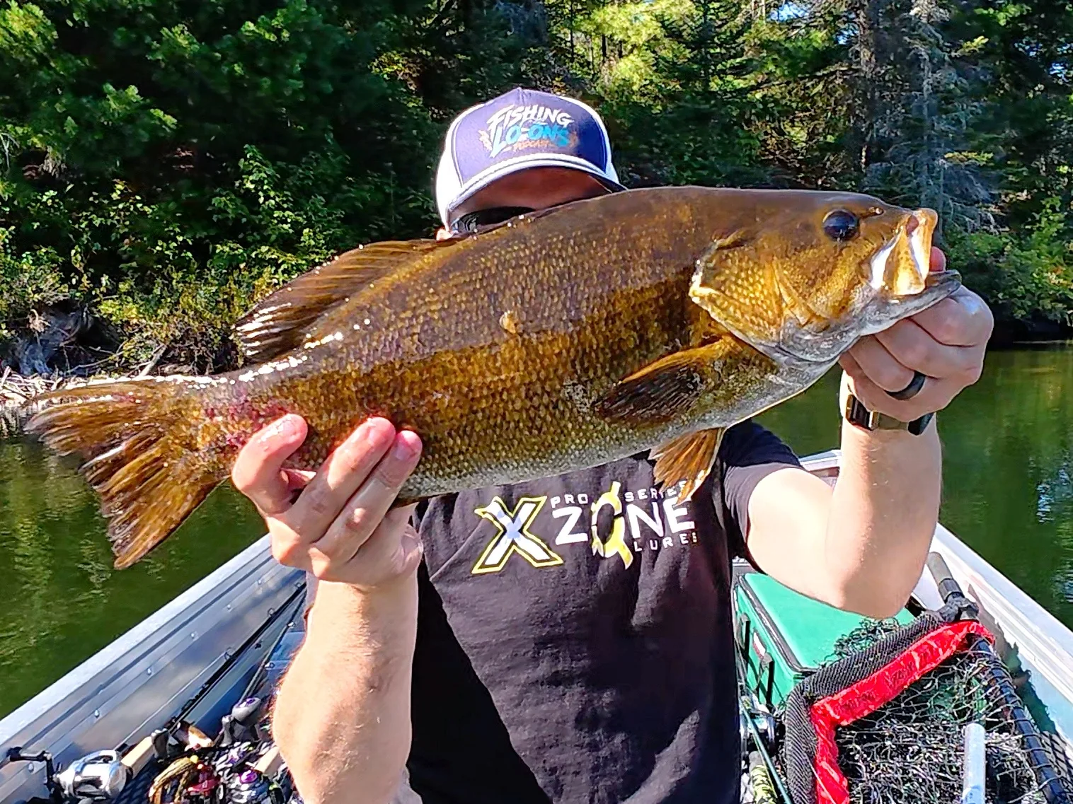 Jesse from Fishing Loons holding a smallmouth bass while fishing.