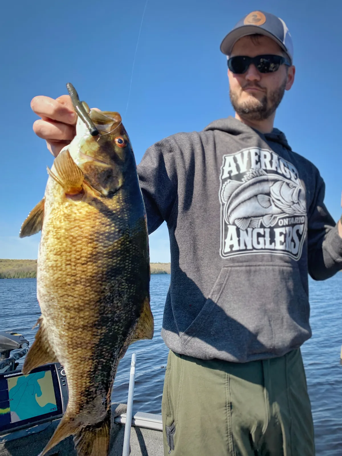 Jesse from Fishing Loons holding a smallmouth bass while fishing.