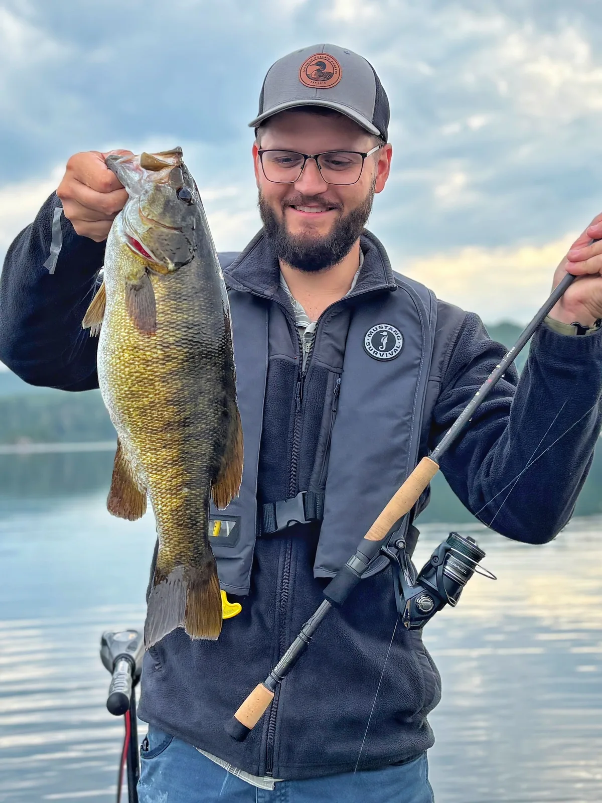 Jesse from Fishing Loons holding a smallmouth bass while fishing.